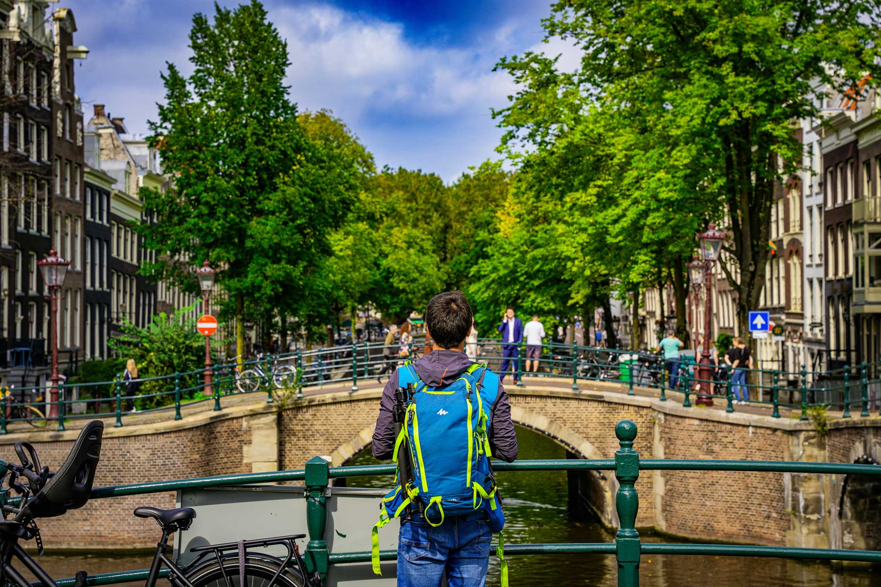 Mann steht auf Brücke an Kanal in Amsterdam